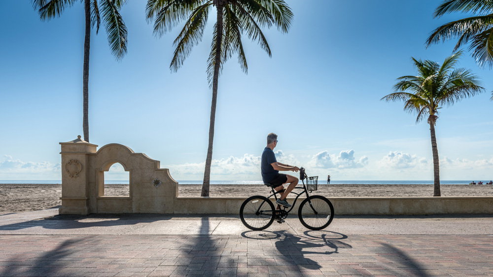 Person rides bike on the sunny seaside