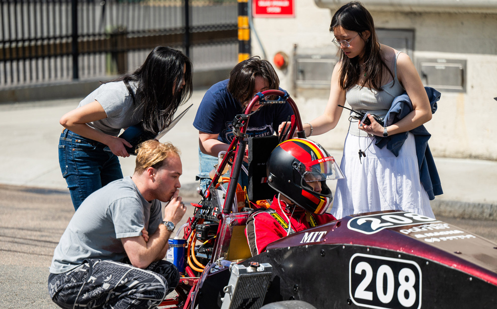 5 students on the Motorsports Team conduct test rides in an alley on MIT’s campus