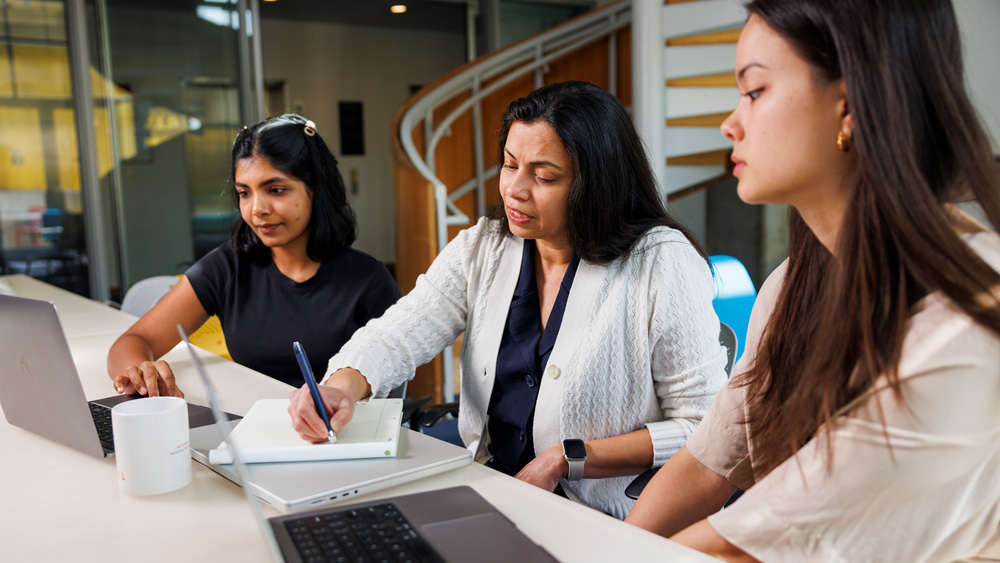3 people at table in discussion