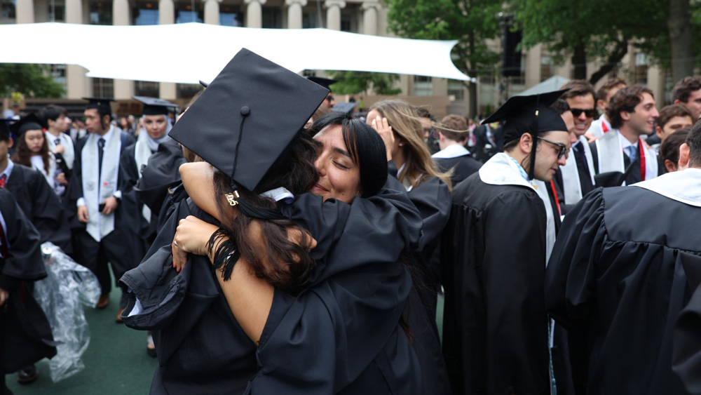 2 grads hug in front of Killian