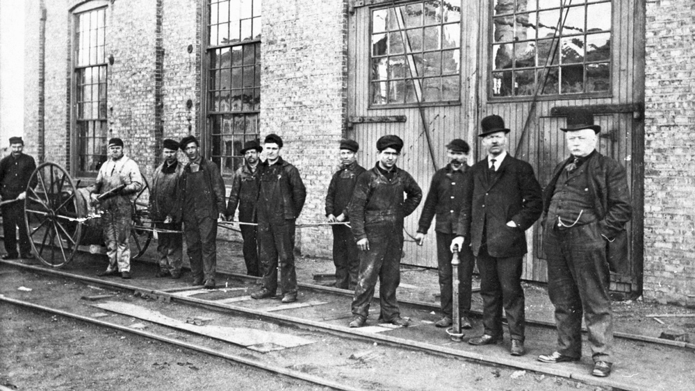 vintage photo of construction workers exiting steel plant