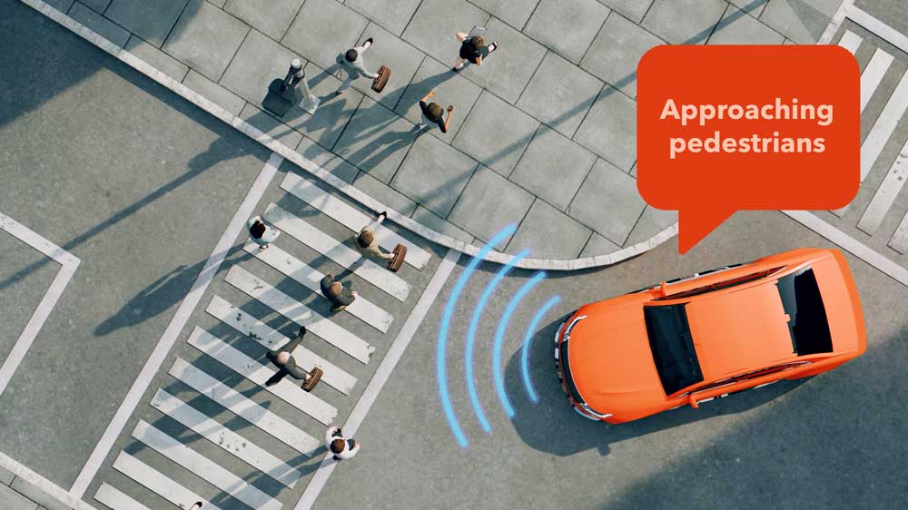 At intersection with pedestrians, a car says "approaching pedestrians"