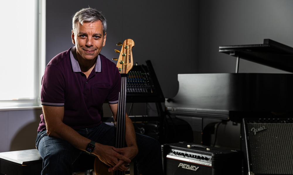 Paris Smaragdis in MIT music studio holding a guitar