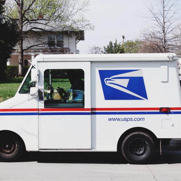 A USPS truck is parked in a residential neighborhood.