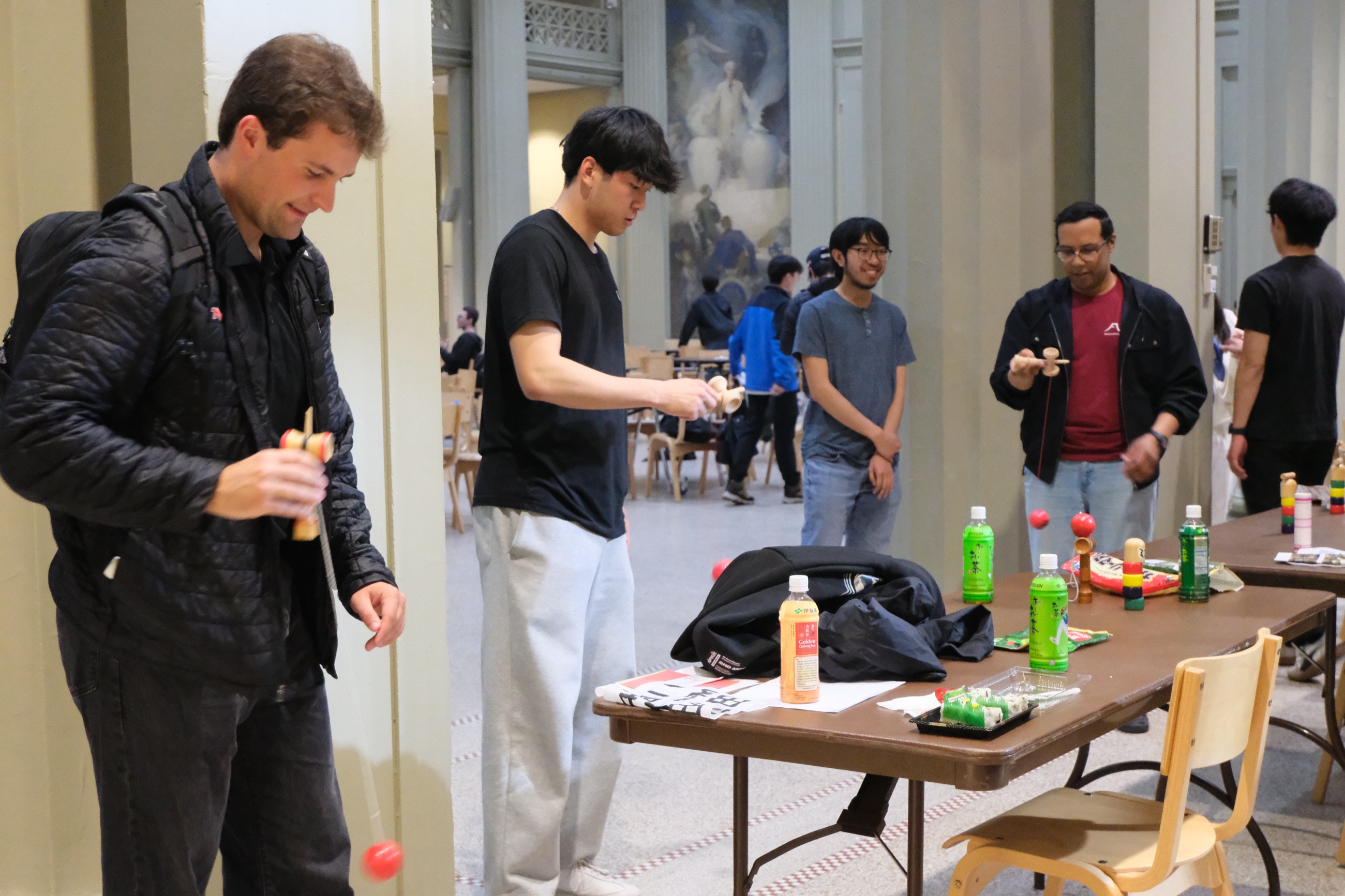 Visitors trying kendama at a JAM cultural booth