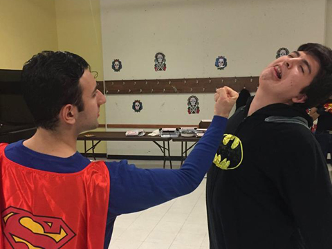 2 LUChA members dressed as Superman and Batman enjoying the halloween party