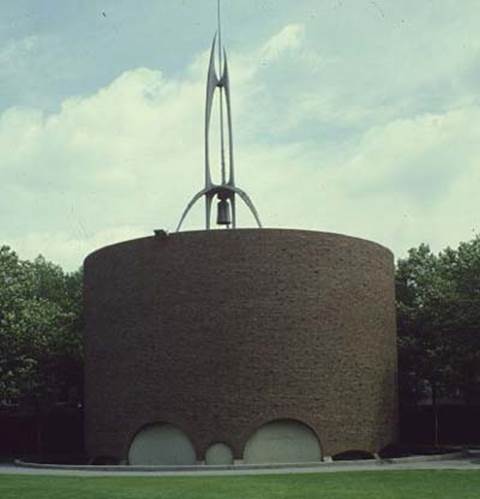 A round building with a rocket on top
Description automatically generated