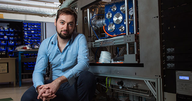 Headshot of grad student Florian Chavagnat in front of instruments in a lab at MIT