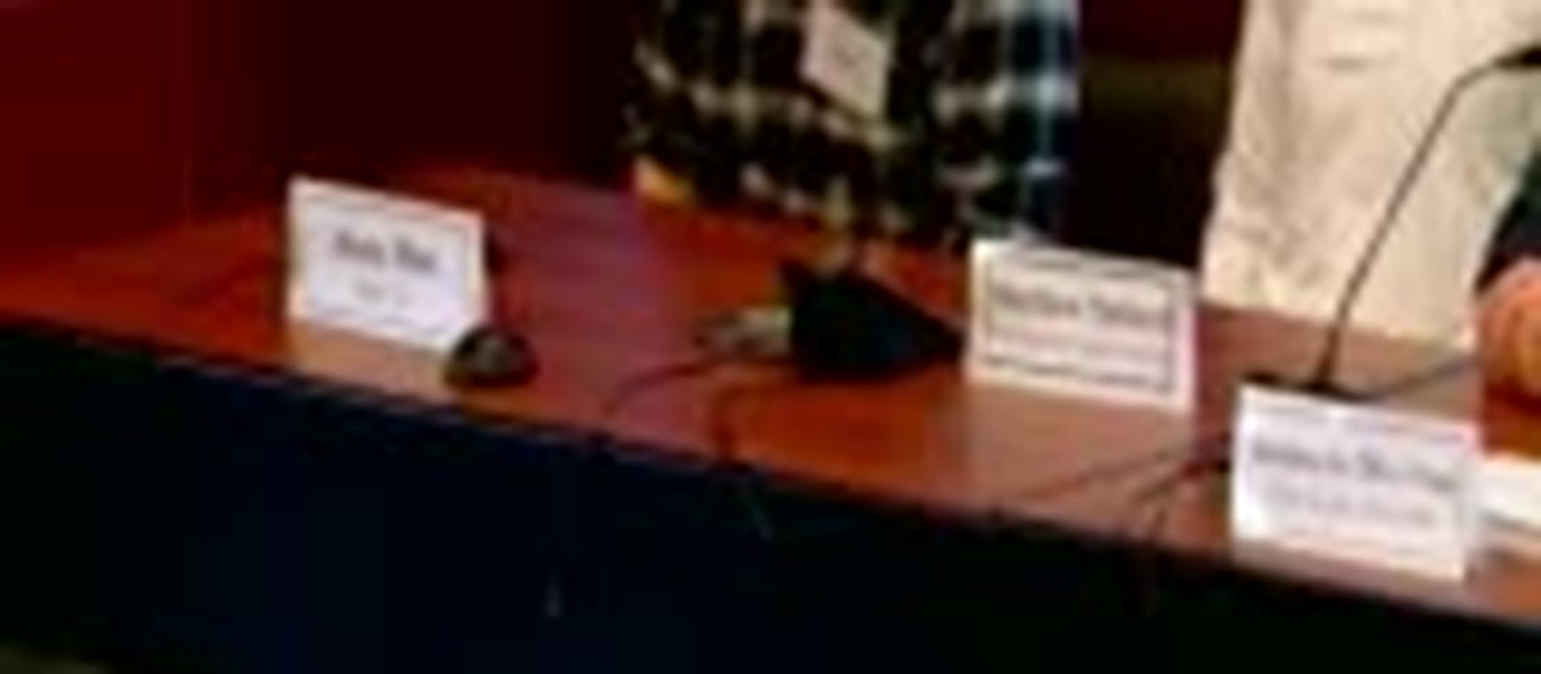 Name placards for two of the panelists — Matt Ballard and Jason Reed — on the dais.